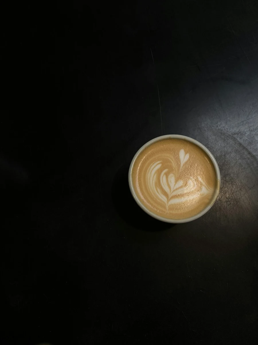 Representative cappuccino in a ceramic cup on a dark table