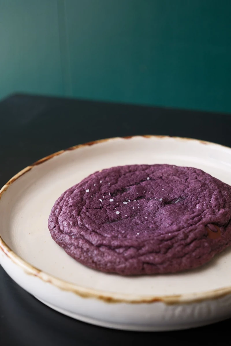 Representative photo of a purple ube cookie on a ceramic plate