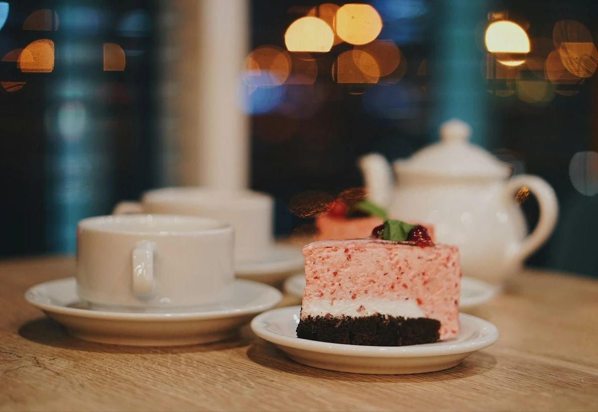 Representative slice of layered cake on a plate beside coffee