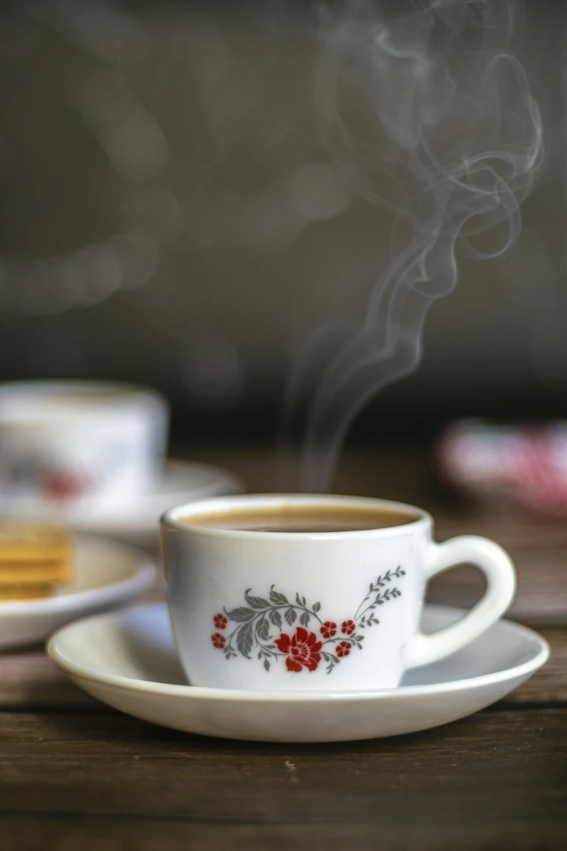 Representative steaming black coffee in a patterned ceramic cup