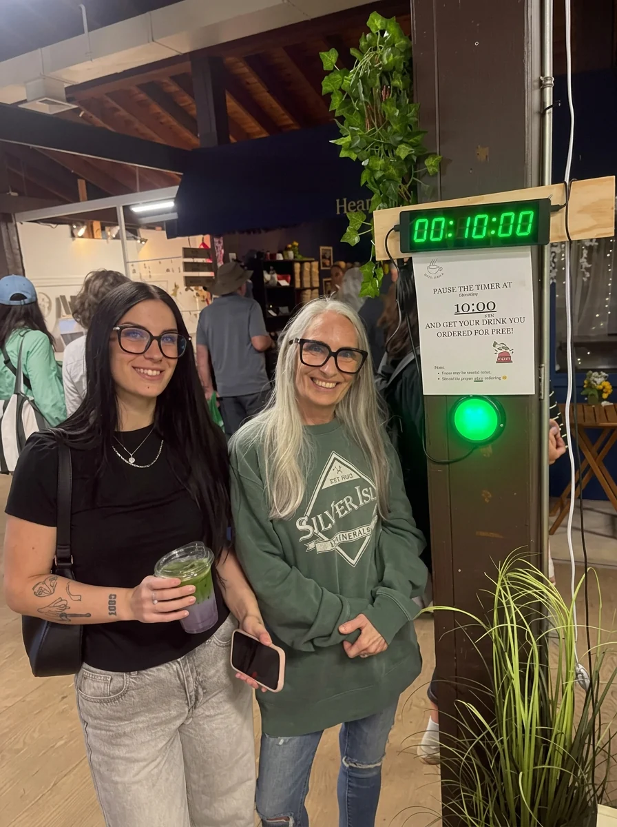 Two customers with iced drinks at the market stall